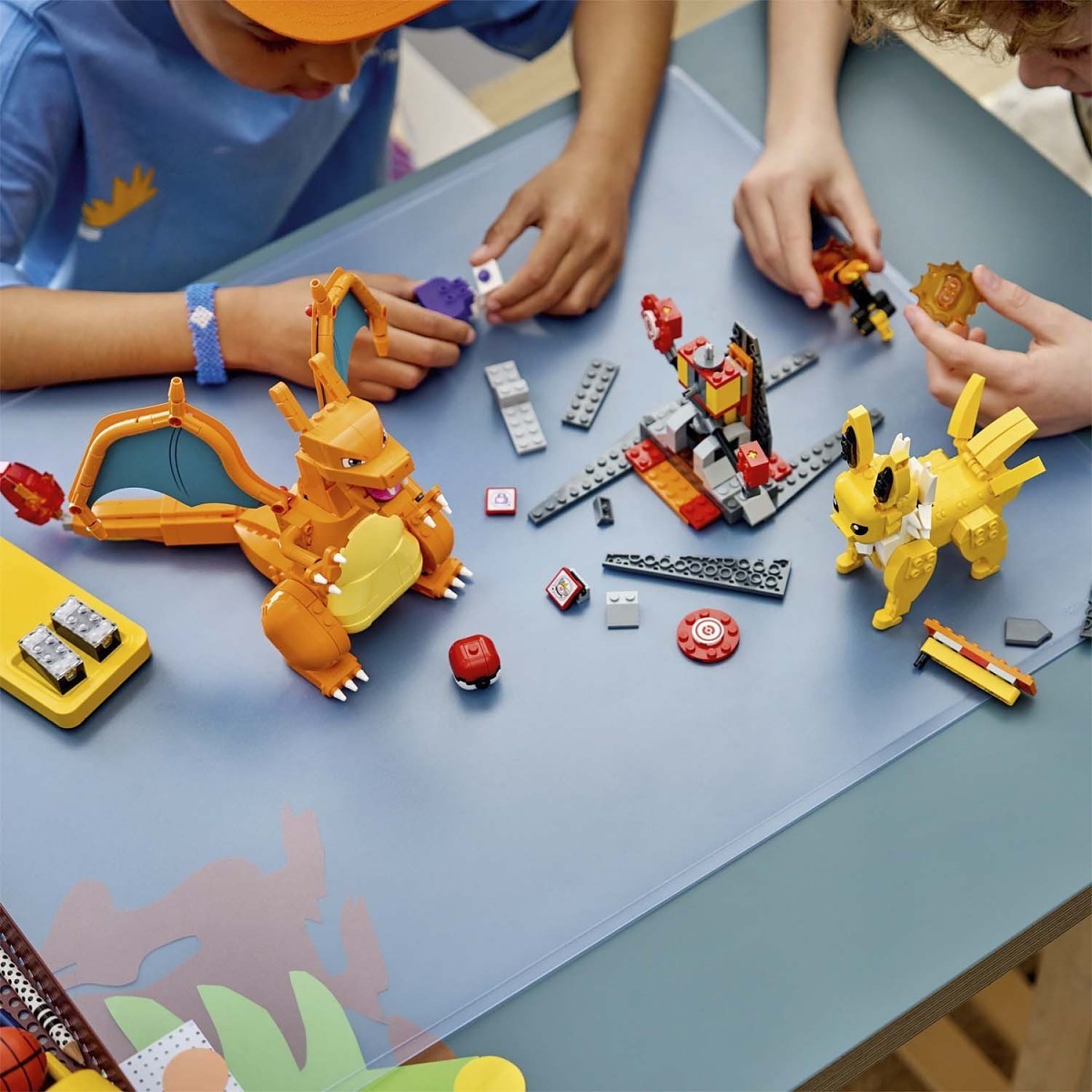 Children playing with colorful toy figures and building blocks on a table.